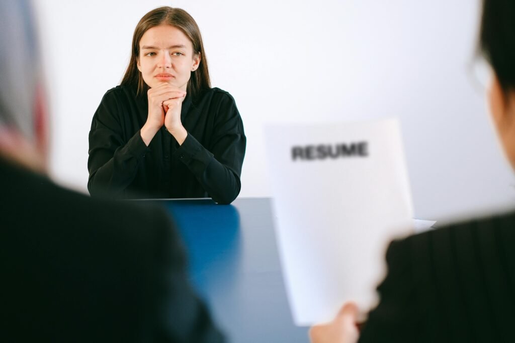 Candidate attending a job interview while recruiters review a resume, highlighting traditional hiring evaluation and culture fit assessment